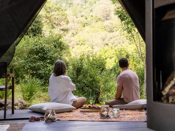 a couple outside a glamping tent at Nightfall, Gold Coast