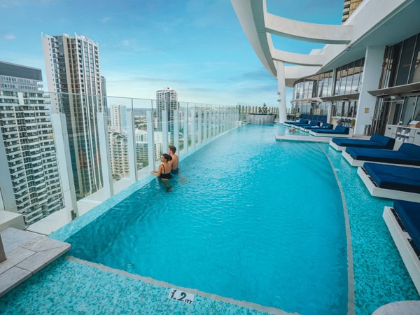 a couple soaking in the rooftop pool of Nineteen at the Star, Gold Coast