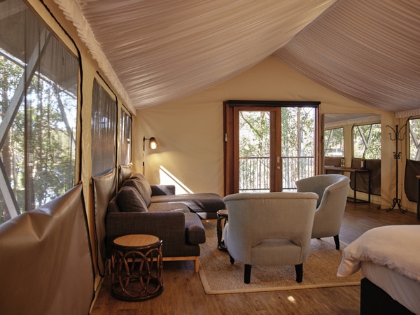 a cosy glamping tent interior with comfortable sofas at Sanctuary by Sirromet Winery, Gold Coast