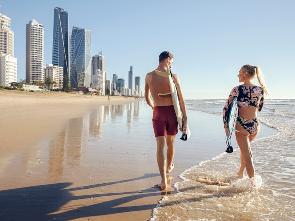 a couple holding their surfboards