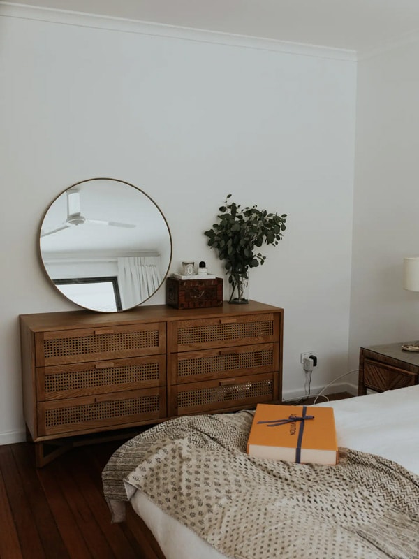 a round-shaped mirror on top of a shelf inside the bedroom at The Tugun Pause