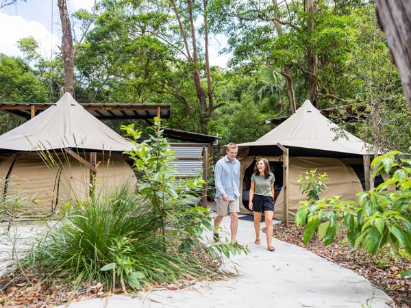a couple walking along the path next to the tents at Thunderbird Park