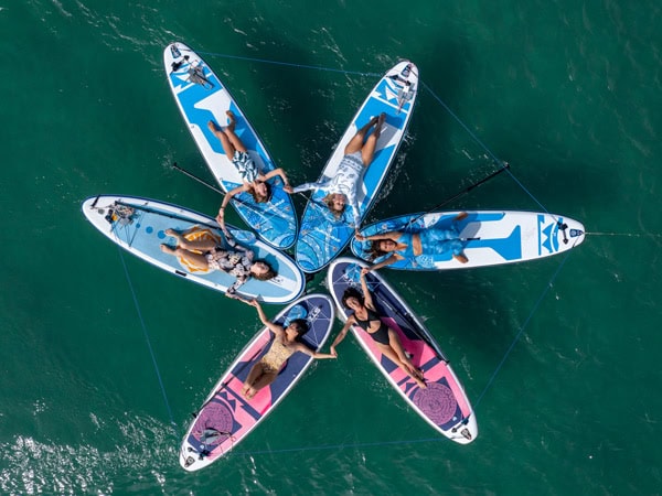 women lying on stand-up paddle boards, Pure Aloha Yoga