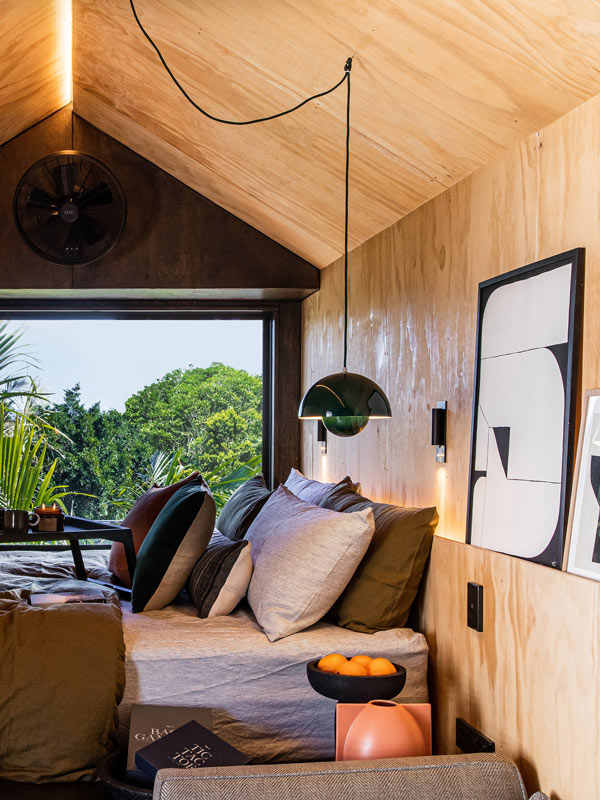 a cosy bed in a tiny house-inspired cabin at qtQT Gold Coast