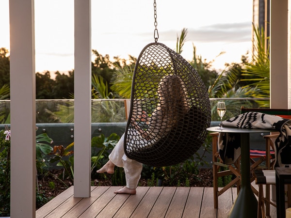 a woman relaxing in a hammock at qtQT Cabins Gold Coast