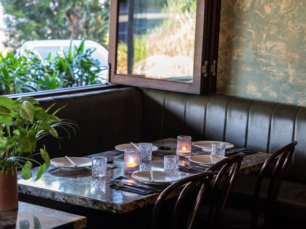 a dining table facing a window at Bang Bang Noosa