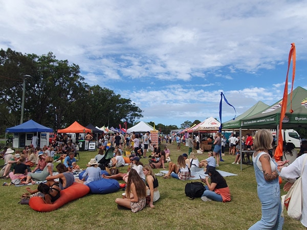 people sitting down on the ground at Byron Farmers Market