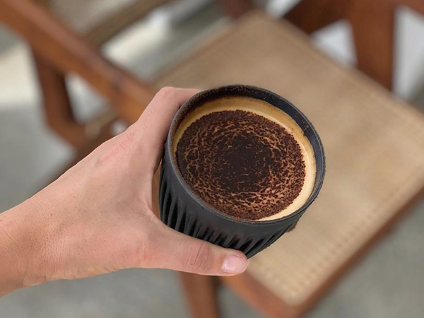 a hand holding a cup of coffee at Daily Counter, Byron Bay
