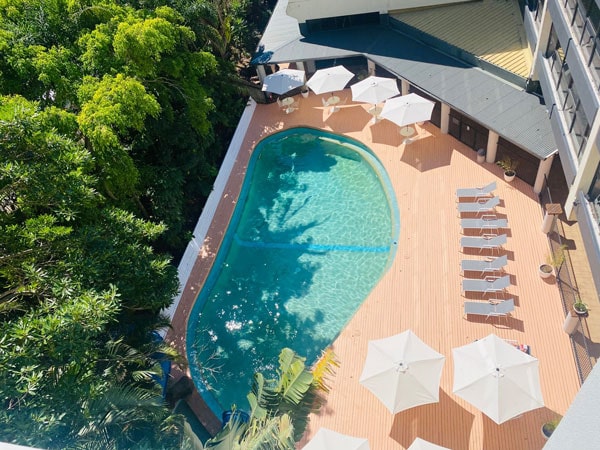 a pool with sun loungers at Greenmount Beach House