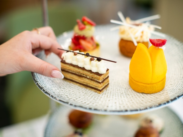 a hand reaching for a slice of cake.