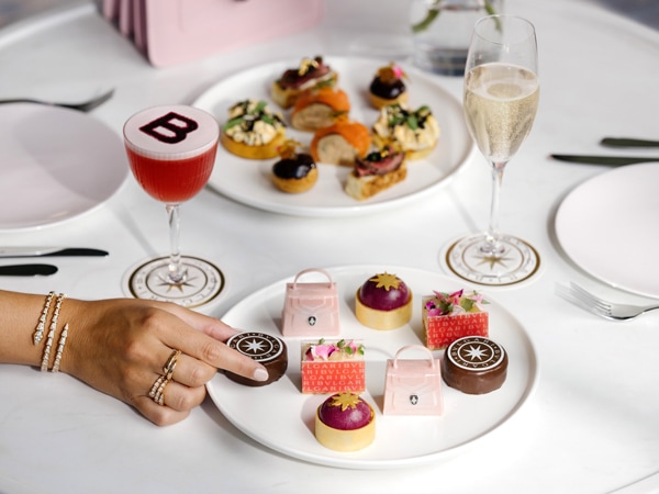 a hand reaching for mini desserts atThe Langham, Gold Coast 