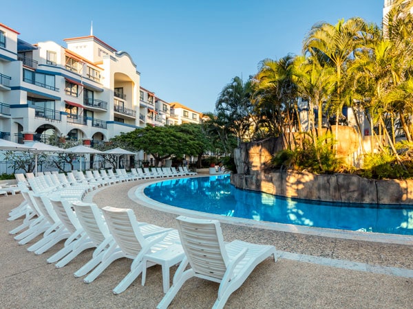 sun loungers on the side of the pool at Oaks Gold Coast Calypso Plaza Suites