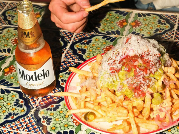 a plate of fries alongside a bottle of beer at Paradise Arcade, Noosa