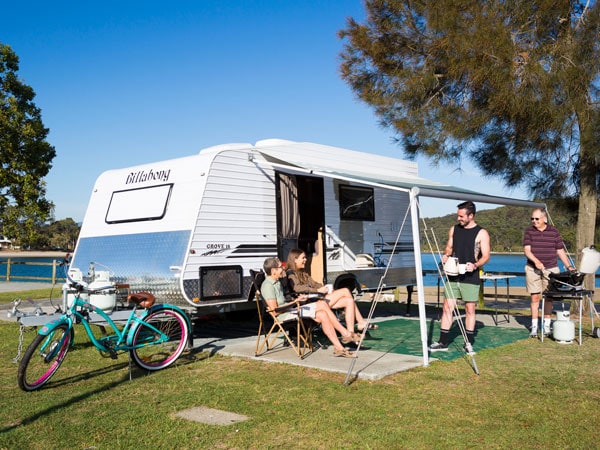 a family hanging out at the BBQ party outside their caravan in Tallebudgera Creek Tourist Park