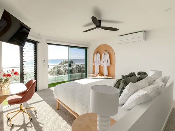 a bedroom with windows that open up to sea views at Tessa’s on the Beach