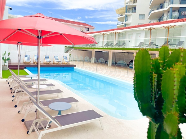 an outdoor pool with sun loungers at Tessa's on the Beach