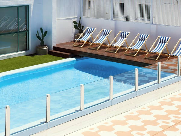 an outdoor pool with chairs at Tessa's on the Beach