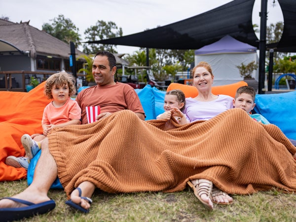 a family relaxing on the ground with a blanket at Treasure Island Resort