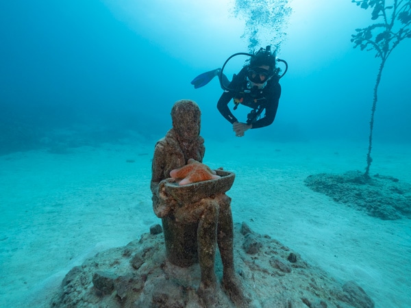 a diver discovering an underwater sculpture, MOUA (Museum of Underwater Art)