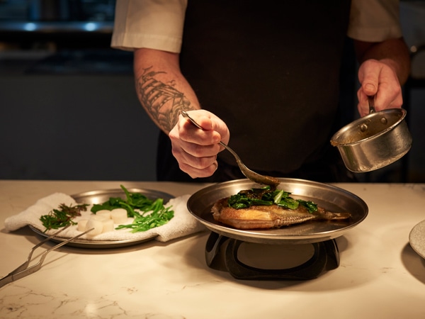 chef de cuisine, Rob Cockerill placing the finishing touches on a dish at Bennelong Restaurant, Sydney