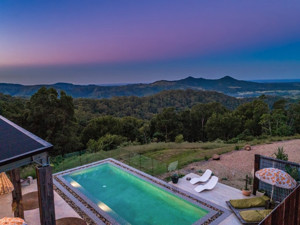 an outdoor pool at Blackbird Byron with scenic mountain views on the background
