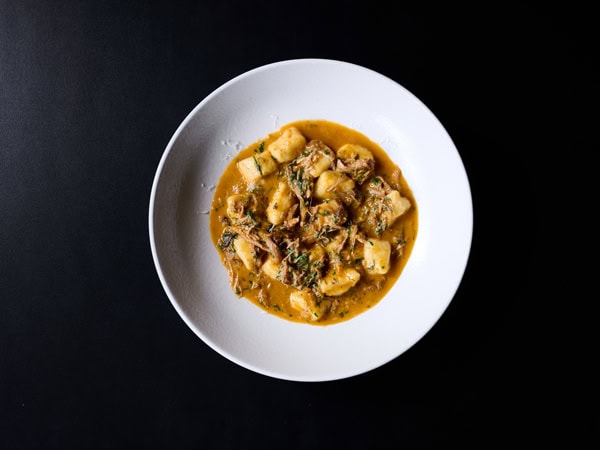 a plate of food on black background at eightysix south, Canberra