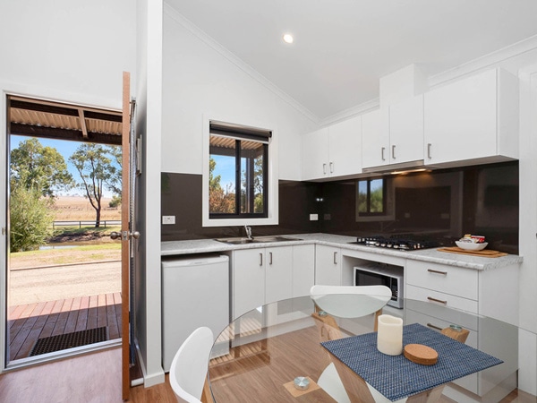 a kitchen and dining area inside the deluxe room at Horseshoe Tourist Park