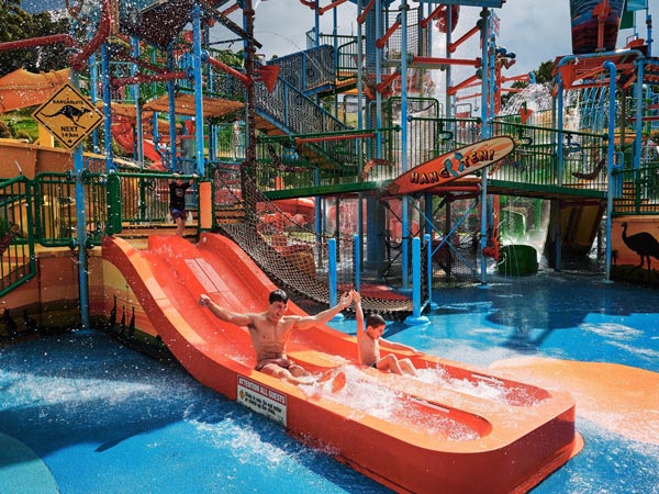 a father and son having fun at a waterslide in the Kiddies Cove, Jamberoo Action Park, Kiama