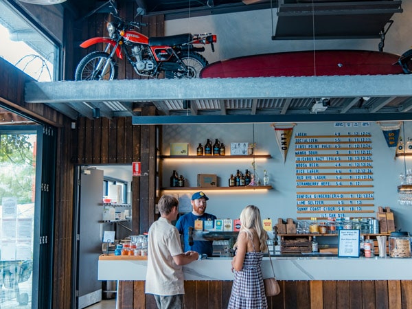 Couple buying drinks at the bar of Land & Sea Brewery, Noosa