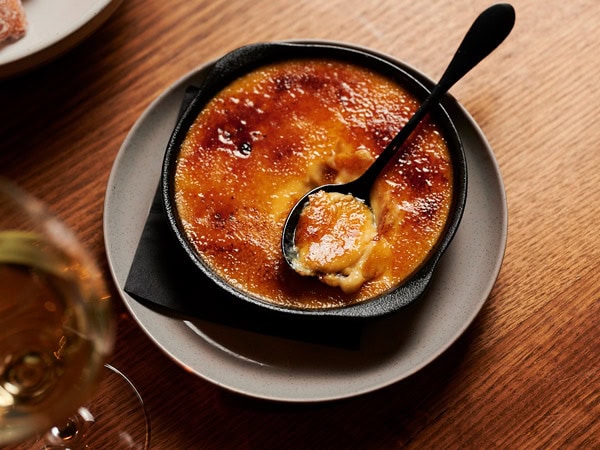 a spoonful of custard dessert on a plate at Ondine, Canberra