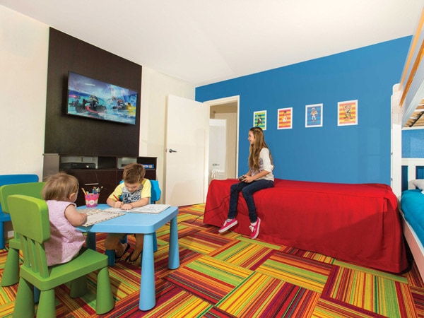 three kids sitting comfortably inside the family suite at Paradise Resort Gold Coast