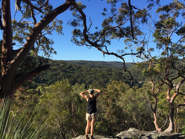 a woman standing on a rock during the hike from Sphinx Memorial to Bobbin Head, Ku-ring-gai Chase National Park