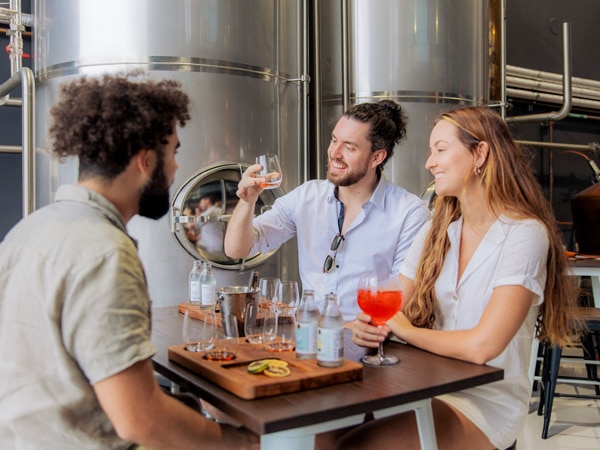 three people enjoying their drinks at 20 20 Distillery