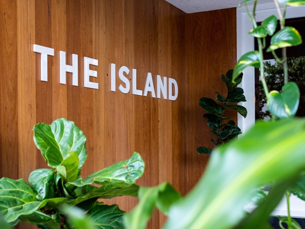The Island Gold Coast signage with plants on the background