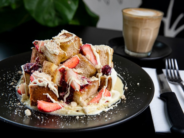a plate of dessert with a glass of coffee on the side at Trail St Coffee Shop, Wagga Wagga