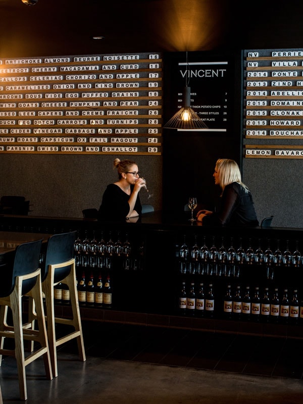 two women drinking wine together at Vincent, Canberra