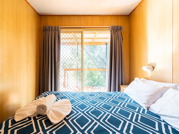 a cosy bedroom inside one of the cabins at Wagga Wagga Tourist Park
