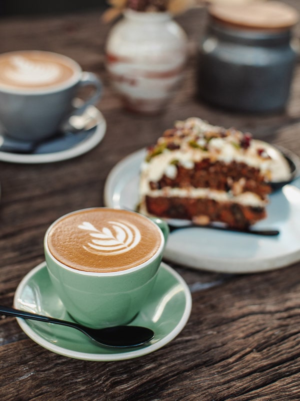 a cup of coffee with a slice of cake at Flying West Coffee Roasters