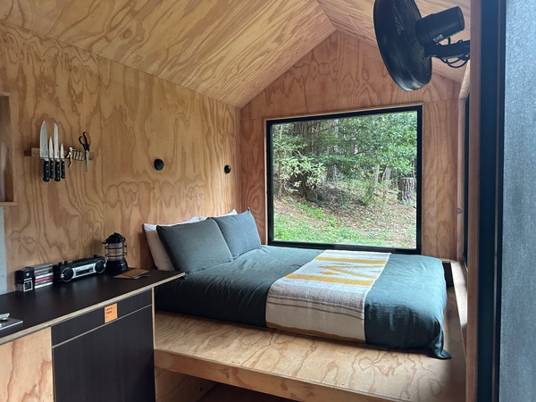 a rustic bedroom with a huge glass window at Unyoked cabin