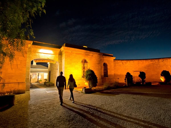 two people entering Old Mount Gambier Gaol at night