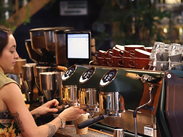 a barista operating a coffee machine at Clandestino Coffee