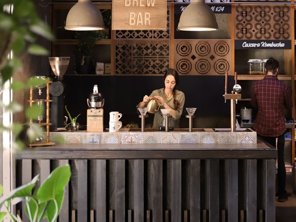 a barista at Clandestino Coffee making pourover coffee