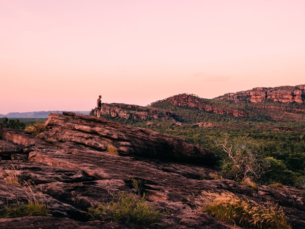 a man standing on top of rock formations in Kakadu