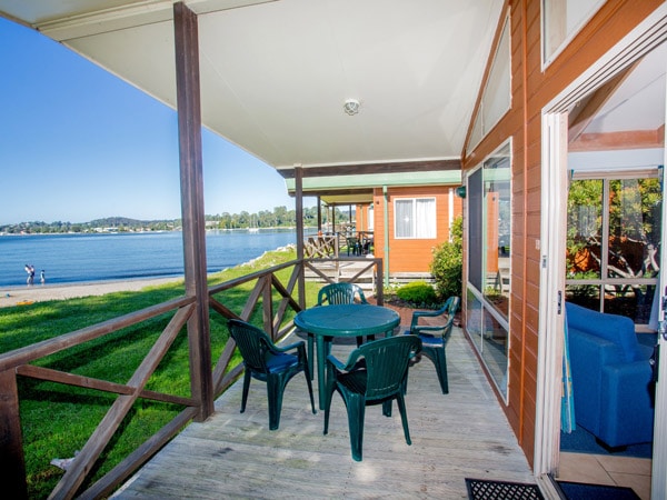 a balcony with chairs and a table at BIG4 Batemans Bay at East's Riverside Holiday Park