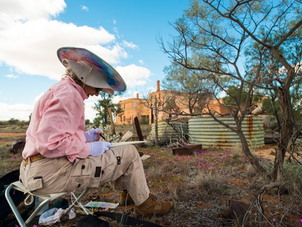 a woman sitting by the Big Bell townsite, WA