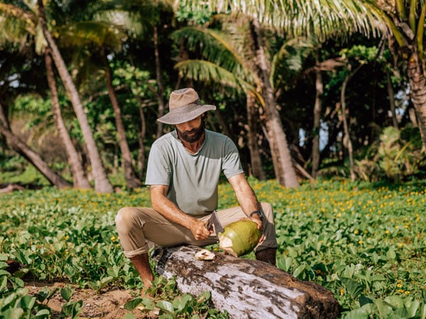 Man with coconut near Bramston Beach