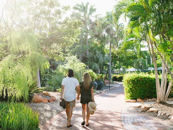 a couple walking side by side in the garden at Cable Beach Club Resort and Spa