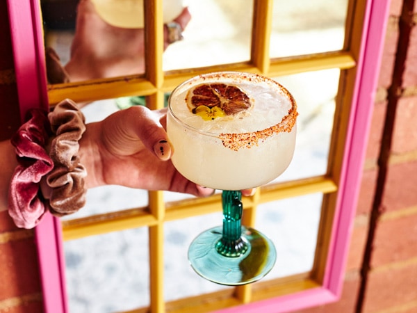 a hand holding a classic margarita at Hecho In Mexico