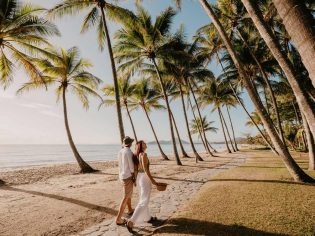 a couple walking on the Palm Cove Beach