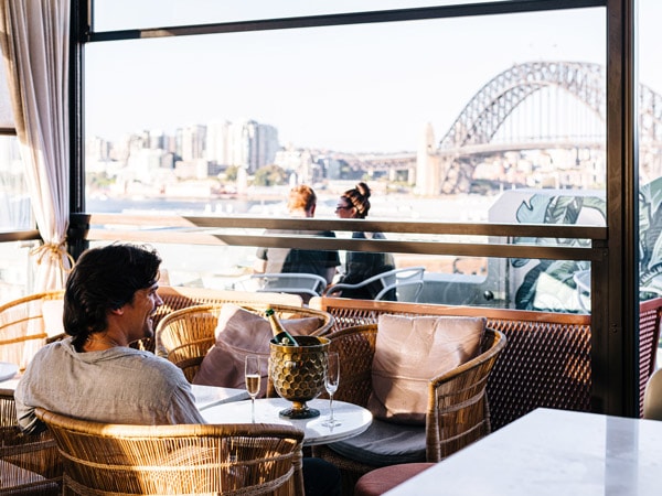 a man facing the view of Sydney Harbour Bridge at Henry Dean